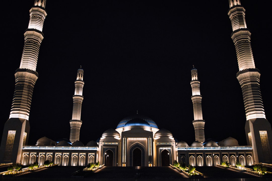Grand mosque illuminated at night with tall minarets