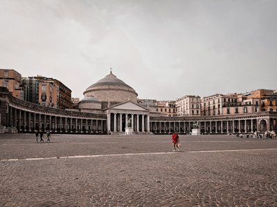 a large courtyard with a domed building in the background