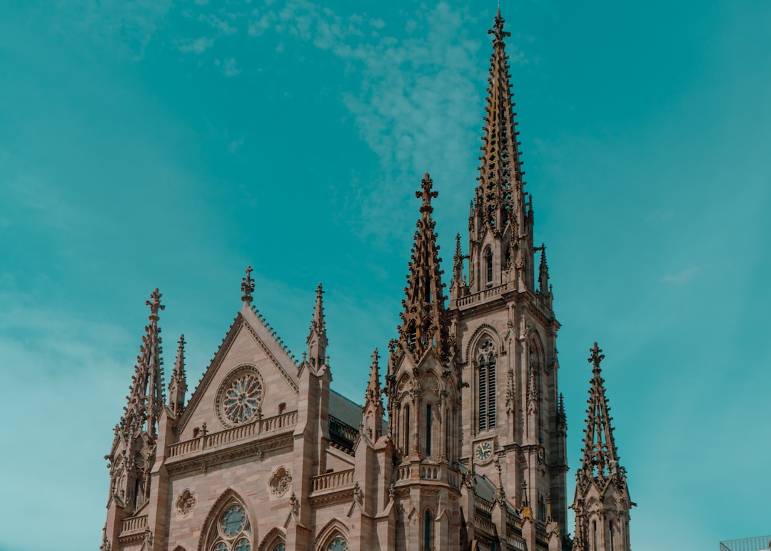 A gothic church towers over the blue sky.