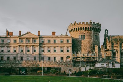 a large castle like building with a green field in front of it