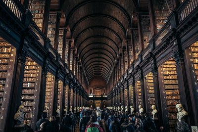 Grand library interior with towering bookshelves and people