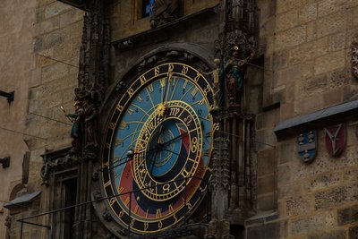Close-up of an ornate astronomical clock on a building.