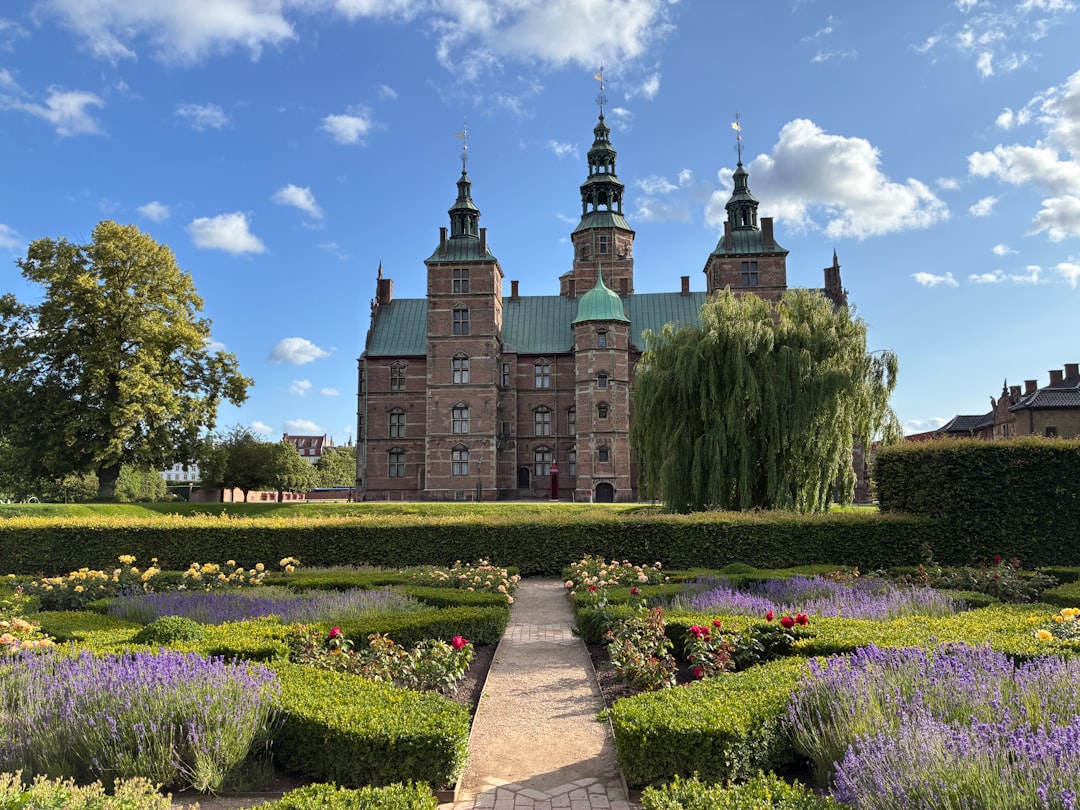 A historic castle with formal gardens on a sunny day