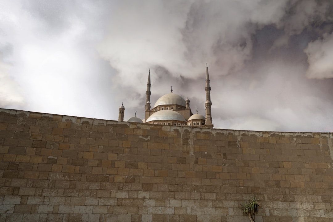 Mosque with minarets behind stone wall
