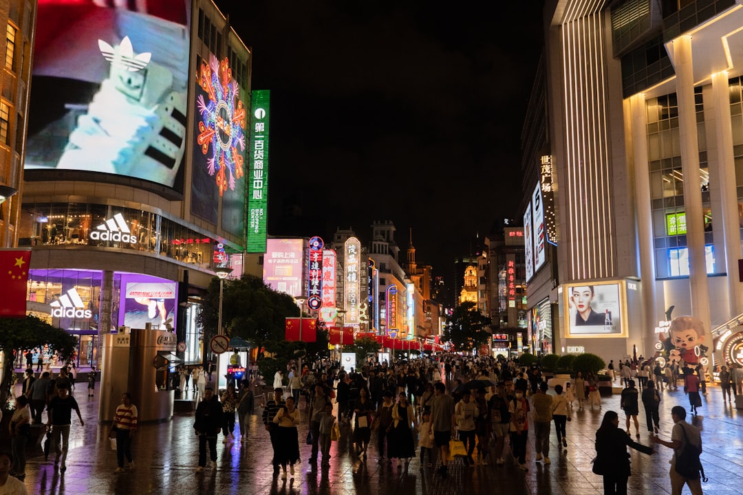 a crowd of people walking down a street next to tall buildings