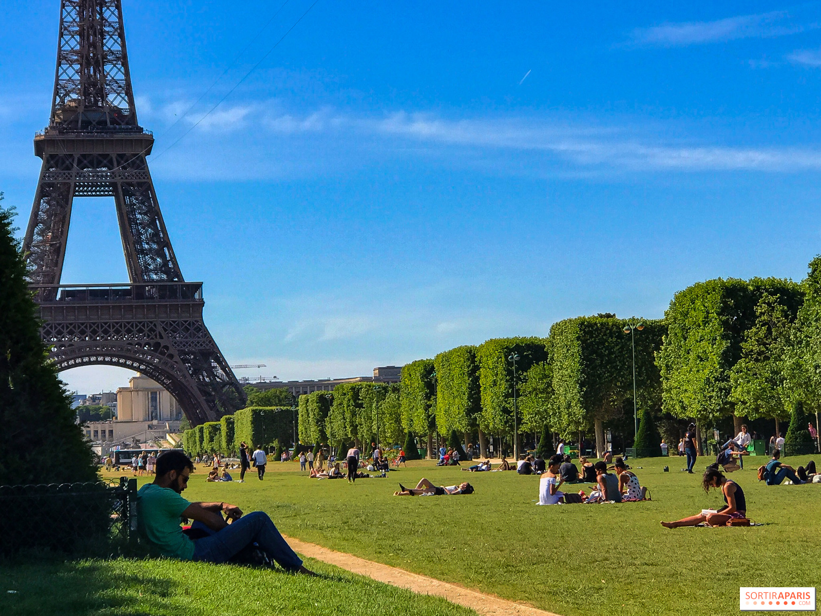 Champs de Mars, a spacious park with green lawns leading to the Eiffel Tower.