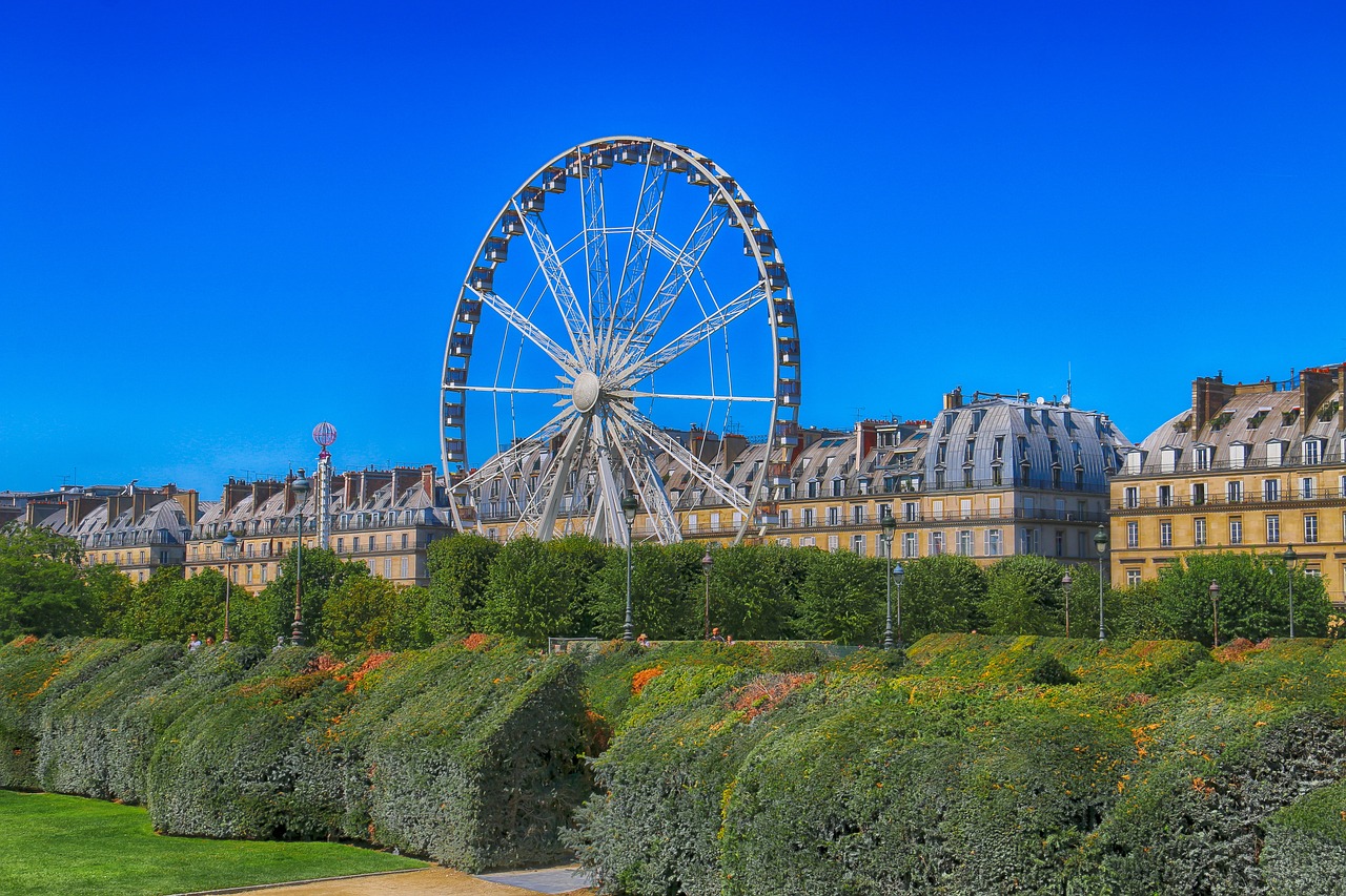 The Tuileries Garden with blooming flowers and paths leading to the Louvre.