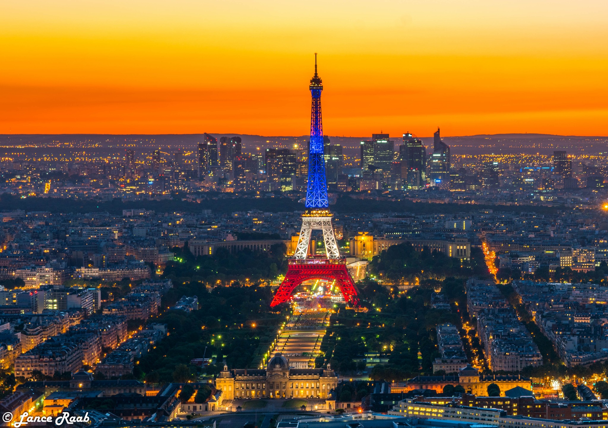 The Eiffel Tower lit up in the colors of the French flag at night.