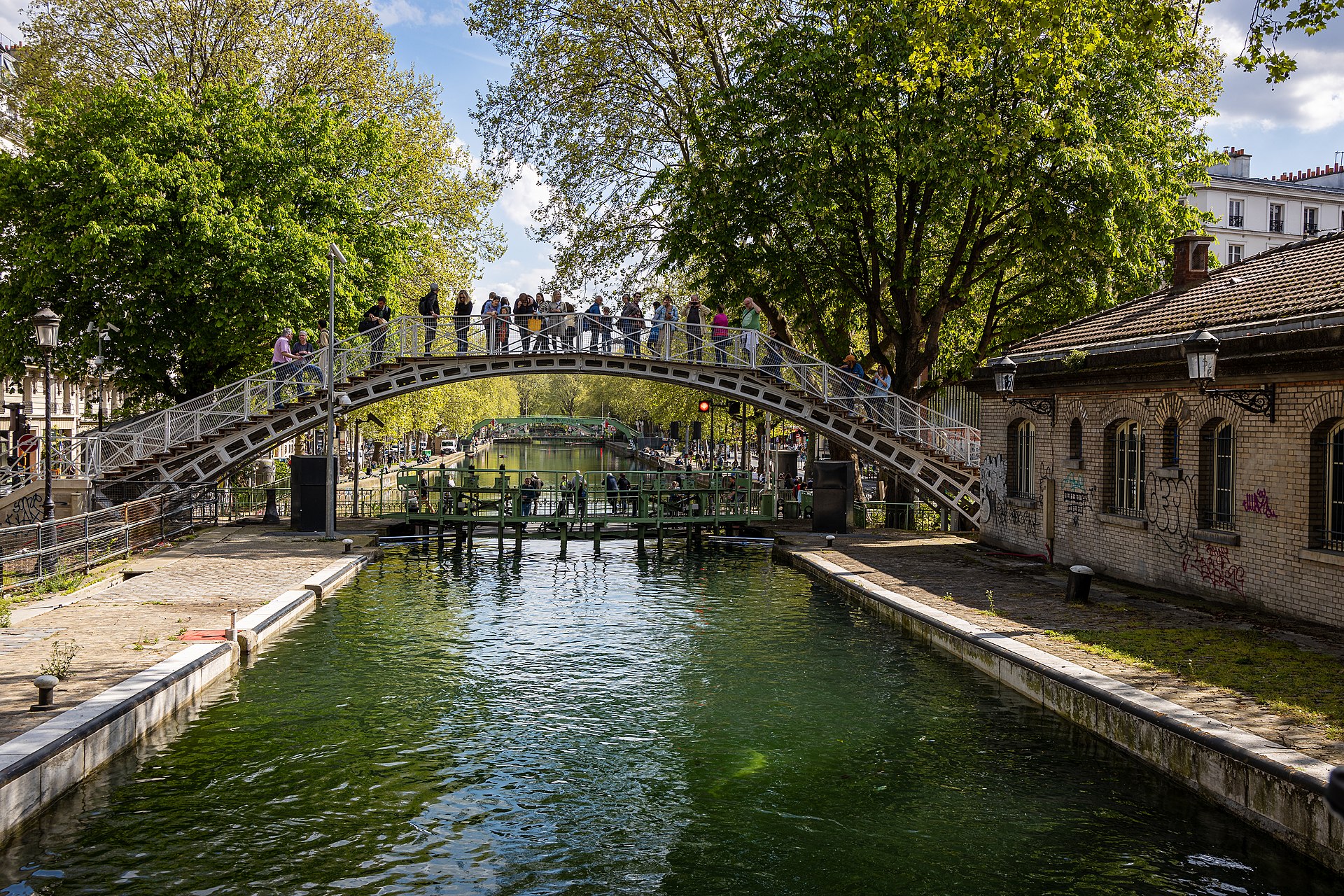 Canal Saint-Martin, where locals stroll along iron bridges and scenic canals.