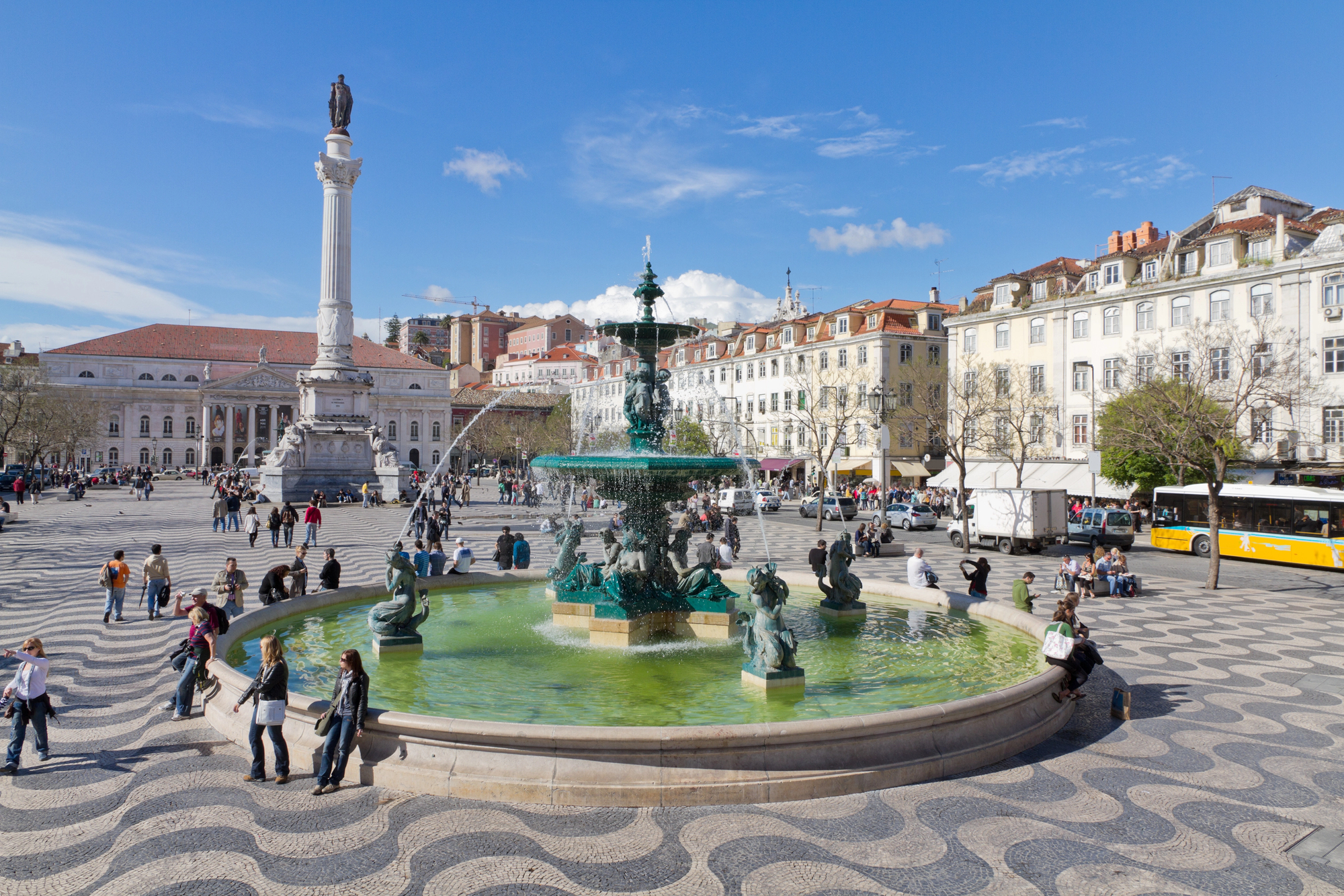 Rossio Square, a lively Lisbon plaza with historic buildings, fountains, and bustling crowds.